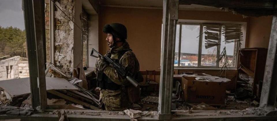 Militar ucraniano vigilante en edificio en ruinas