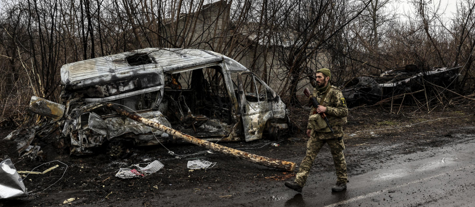 Un soldado ucraniano patrulla junto a un vehículo quemado en el pueblo de Lukianivka, cerca de Kiev