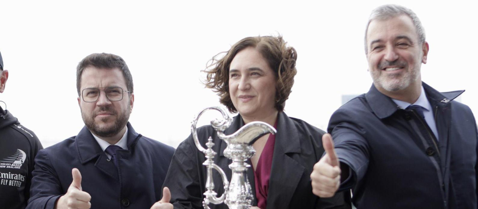 Pere Aragonès, Ada Colau y Jaume Collboni sonríen junto al trofeo de la Copa de América de Vela