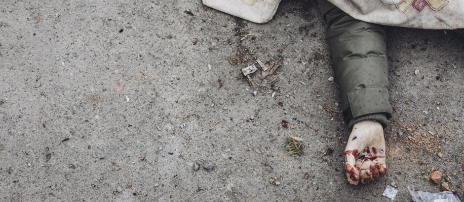El cadáver de una persona por los bombardeos rusos yace cubierto en la calle de la ciudad de Irpin, Ucrania