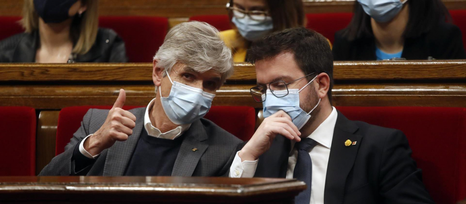 El presidente de la Generalitat, Pere Aragonès, en su escaño junto al conseller de Salud, Josep Maria Argimon (i), durante la segunda jornada del pleno del Parlament