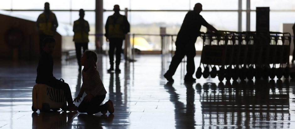 Dos jóvenes viajeras juegan en una de las terminales del Aeropuerto Adolfo Suárez Madrid-Barajas este miércoles