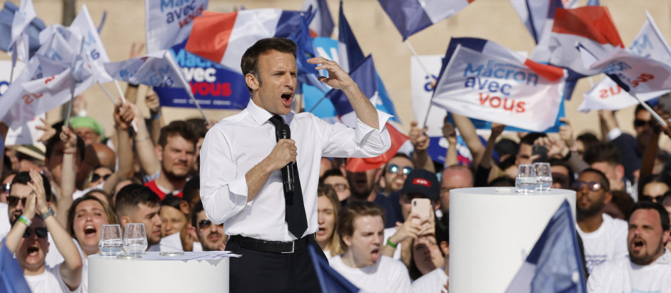 France's President and La Republique en Marche (LREM) candidate for re-election Emmanuel Macron (C), surrounded by supporters, speaks during an election campaign meeting in Marseille, southern France on April 16, 2022, ahead of the second round of voting in France's presidential election. (Photo by Ludovic MARIN / AFP)