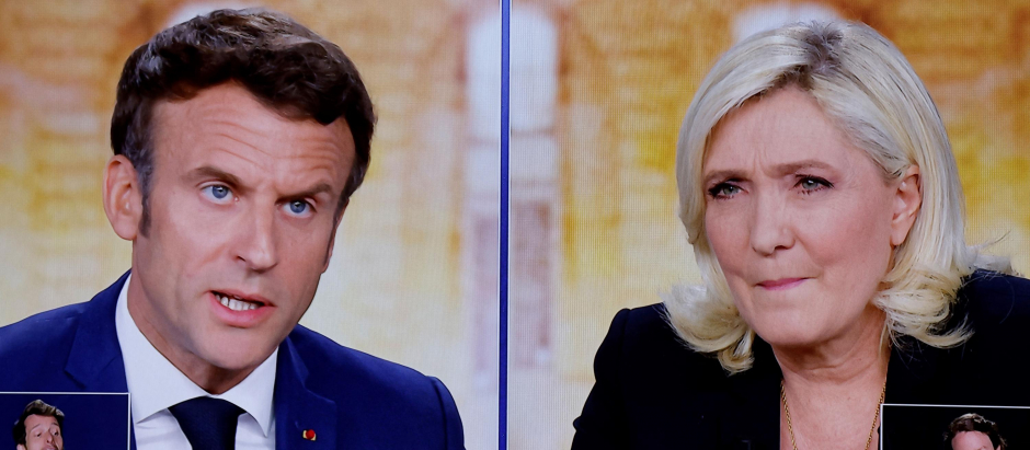 A picture shows screens displaying a live televised debate between French President and La Republique en Marche (LREM) party candidate for re-election Emmanuel Macron (L) and French far-right party Rassemblement National (RN) presidential candidate Marine Le Pen (R), broadcasted on French TV channels TF1 and France 2, in a viewing roon at the studios hosting the debate in Saint-Denis, north of Paris, ahead of the second round of France's presidential election. - French voters head to the polls for a run-off vote between Macron and Le Pen on April 24, 2022. (Photo by Ludovic MARIN / AFP)