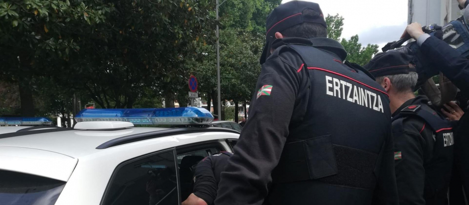 Agentes de la Ertzaintza introducen en el coche policial al detenido por su los homicidios de homosexuales en Bilbao, tras elñ registro en su domicilio de Irun