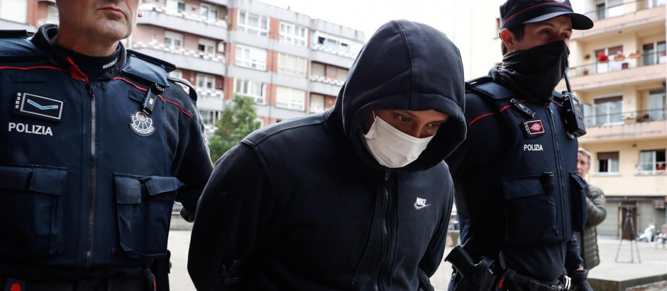 gentes de la Ertzaintza trasladan al detenido por su presunta vinculación con los asesinatos de hombres en Bilbao tras registrar un piso en la localidad guipuzcoana de Irun
