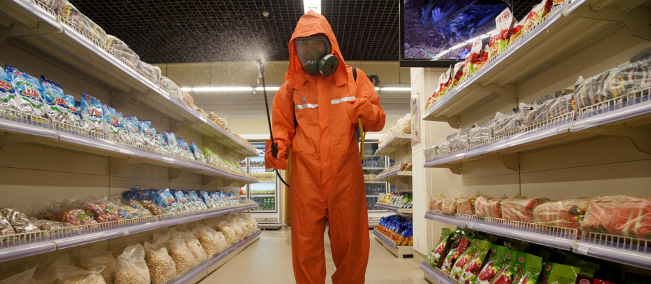 Un funcionario de salud rocía desinfectante en un supermercado norcoreano