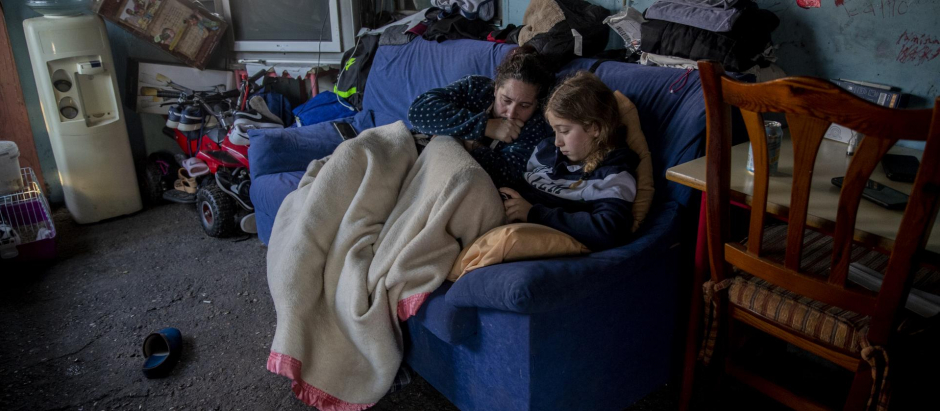 Una mujer descansa con su hija en su casa de la Cañada Real, en Madrid