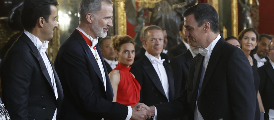 Felipe VI saluda a Pedro Sánchez acompañado por el emir de Catar