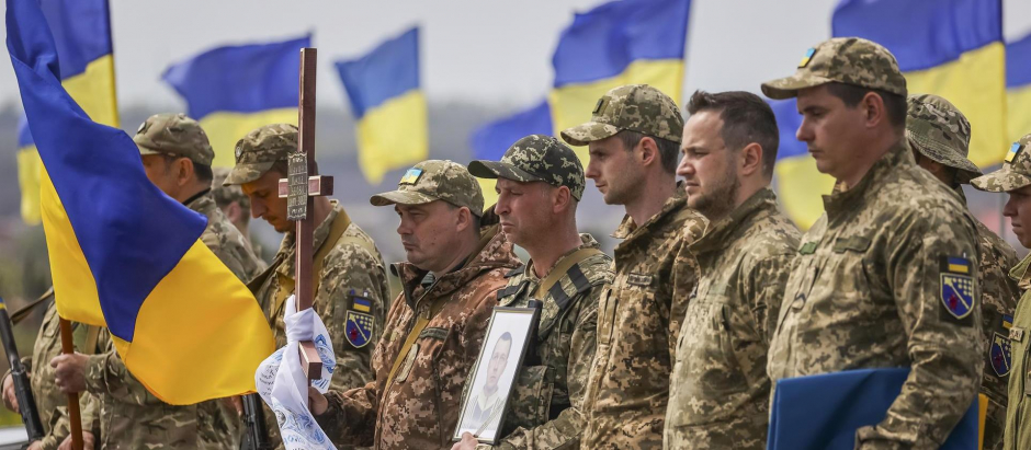 Varios militares ucranianos asisten al entierro de su compañero de armas Mykola en el cementerio militar de Dnipro