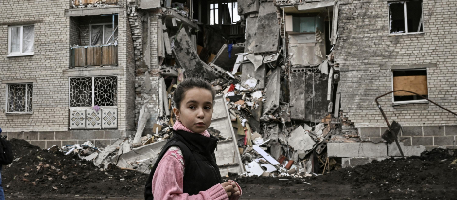 Una niña ucraniana junto a un edificio de apartamentos destruido en la localidad de Bakhmut