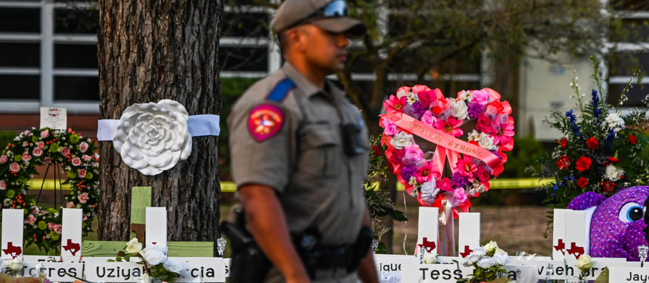 Un policía frente al monumento improvisado para las víctimas del tiroteo afuera de Uvalde, Texas
