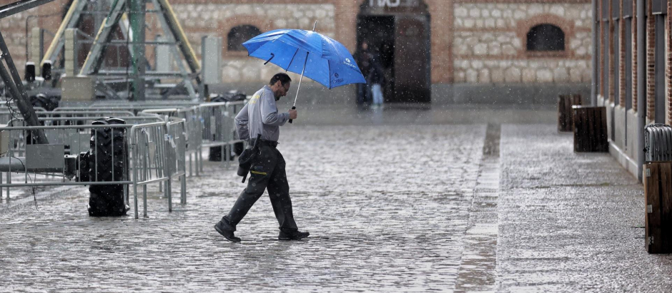 Un hombre se resguarda de la lluvia bajo un paraguas