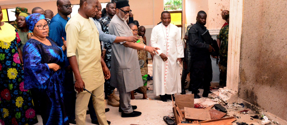 El gobernador del estado de Ondo, Rotimi Akeredolu (3.° a la izquierda), señala sangre en el piso manchado después de un ataque de hombres armados en la iglesia católica St. Francis en la ciudad de Owo, en el suroeste de Nigeria