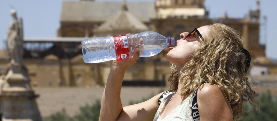 Una turista bebe agua para combatir el calor, en Córdoba, ante las altas temperaturas que registra la Península por la ola de calor