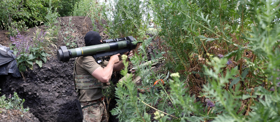 Un soldado ucraniano espera armado entre la maleza, en la región del Donetsk