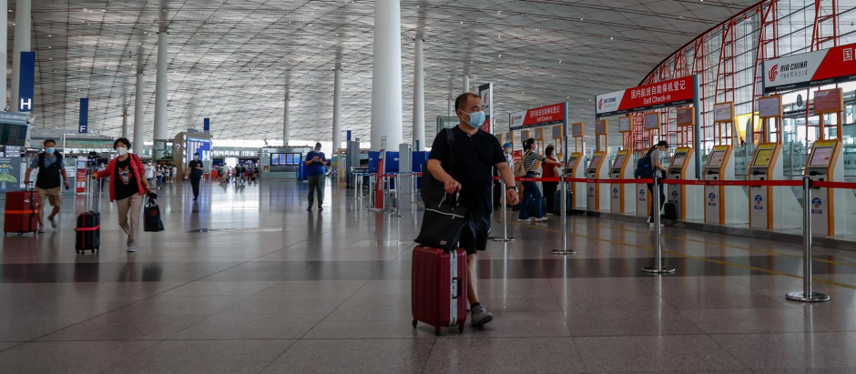 Varias personas caminan por el Aeropuerto Internacional de Pekín, en China, este miércoles. China ha reducido el periodo de cuarentena de las llegadas del extranjero con la permanencia de siete días en un centro gestionado por el gobierno y tres días en arresto domiciliario