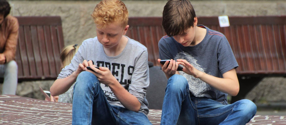 Dos adolescentes con el teléfono móvil