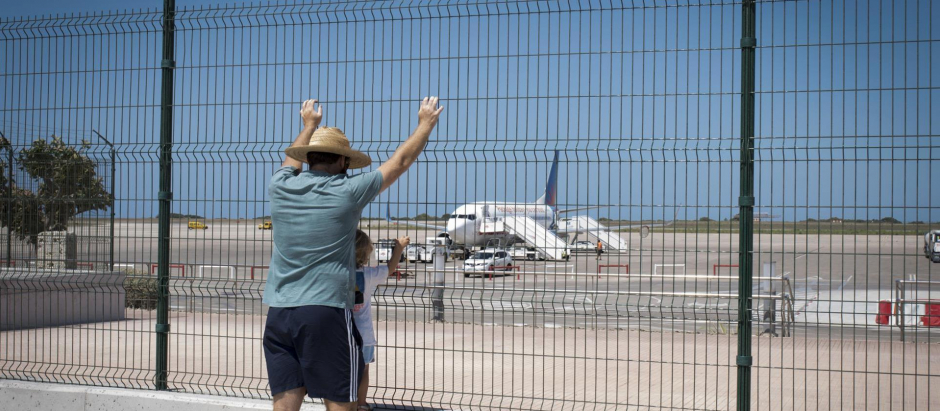 Varias personas observan aviones en aeropuerto de Menorca en el primer día del mes de julio