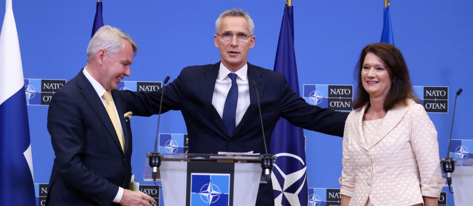 NATO Secretary General Jens Stoltenberg (C) embraces Finnish Foreign Minister Pekka Haavisto (L) and Swedish Ministry for Foreign Affairs Anne Linde after the signing of the accession protocols of Finland and Sweden at the NATO headquarters in Brussels on July 5, 2022. - The process to ratify Sweden and Finland as the newest members of NATO was formally launched on July 5, 2022, the military alliance's chief Jens Stoltenberg said, marking a historic step brought on by Russia's war in Ukraine. (Photo by Kenzo TRIBOUILLARD / AFP)