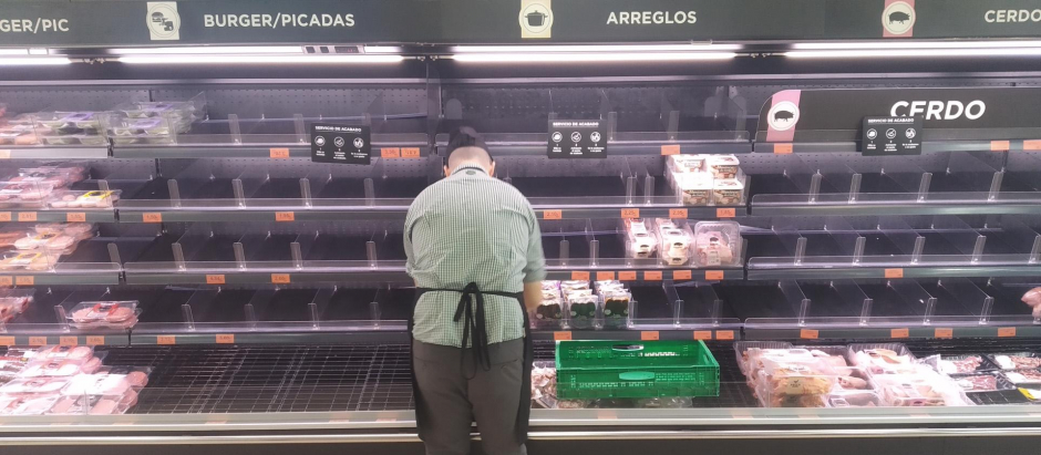 Un empleado coloca productos en un supermercado