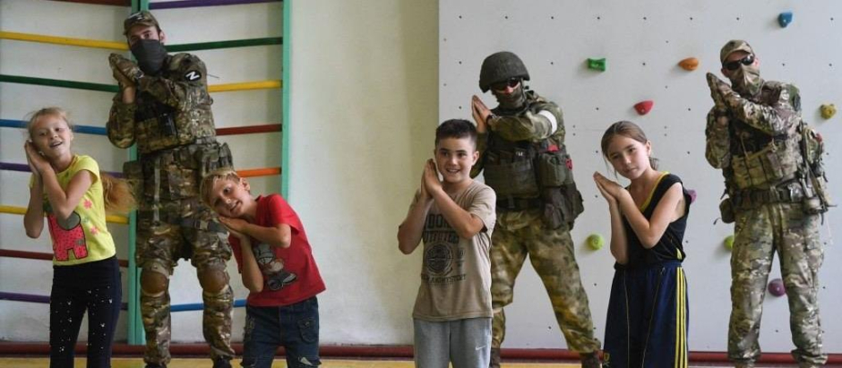 Niños ucranianos junto a soldados rusos