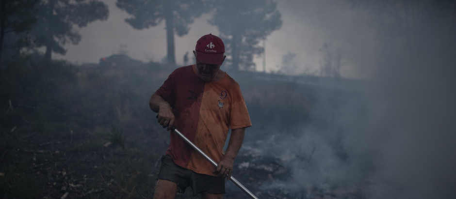 Un hombre realiza labores de extinción en el incendio forestal que permanece activo en Verín.