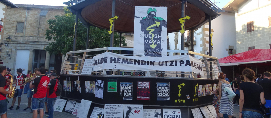 "Fuera de aquí, que nos dejen en paz", dice en euskera la pancarta situada en el kiosko de la Plaza de los Fueros de Alsasua