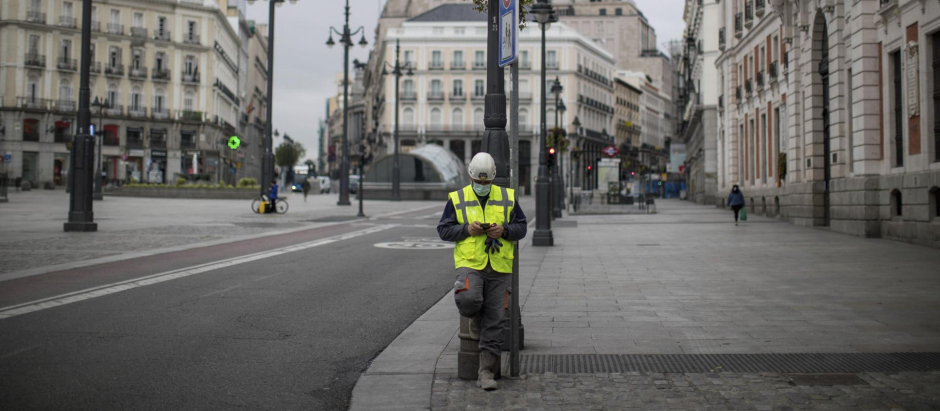 Un trabajador consulta su teléfono en la Puerta del Sol de Madrid