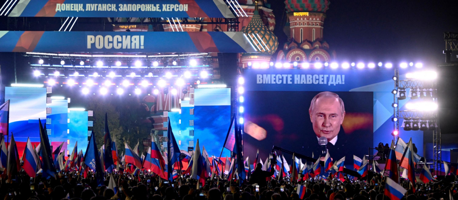 Vladimir Putin se ve en una pantalla en la Plaza Roja de Moscú durante un discurso previo a un concierto