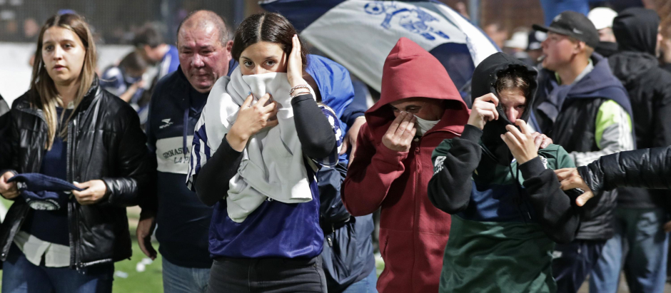 Los asistentes al partido argentino salen del estadio tapándose las vías respiratorias para proteger del gas lacrinógeno