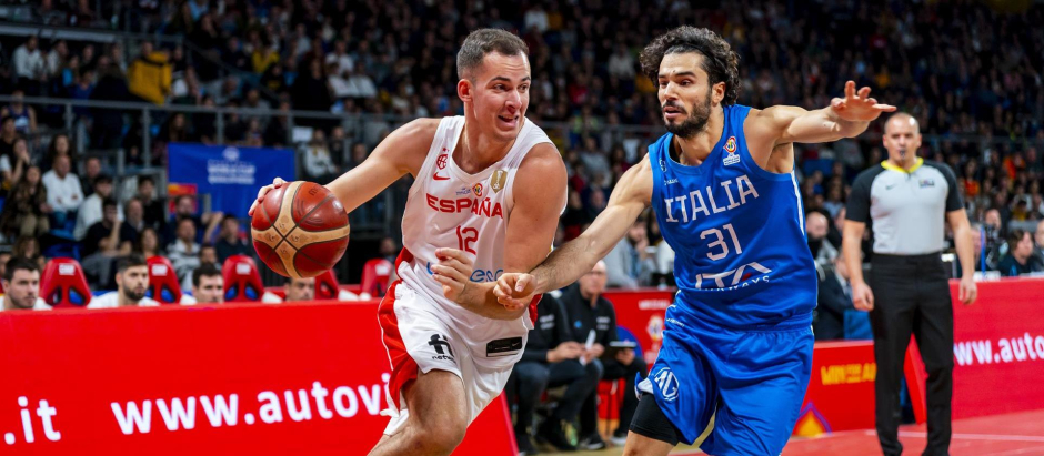 El alero de la selección española de baloncesto Miquel Salvó (i) avanza con el balón perseguido por el jugador de la selección italiana, durante el encuentro clasificatorio para el mundial de baloncesto 2023
