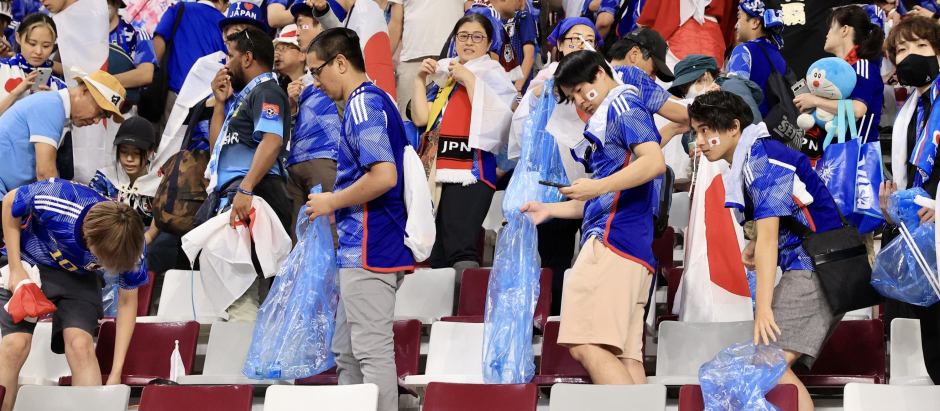 Los aficionados de Japón recogen la basura que han generado durante el partido