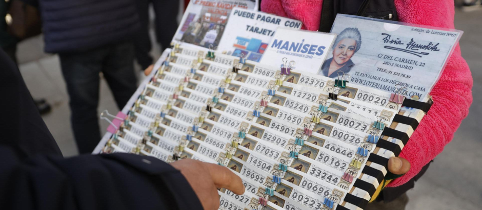 Una lotera vende décimos de Lotería para el sorteo navideño de El Gordo en la Puerta del Sol de Madrid