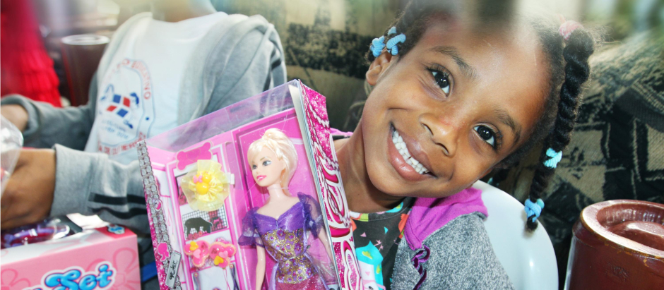 Una niña posa con uno de sus regalos de Reyes