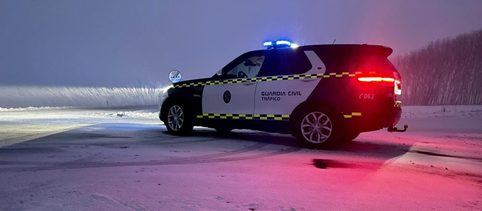 Patrulla de la Guardia Civil en labores de control de tráfico en una carretera nevada