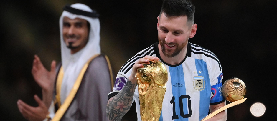 Argentina mira la Copa del Mundo mientras sostiene el trofeo al Mejor Jugador del Torneo