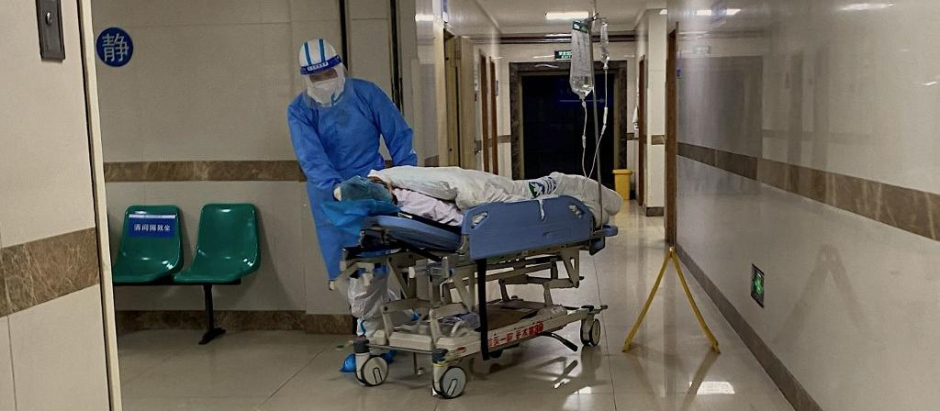 Un enfermero transporta a un paciente de covid en el hospital de Chongqing, al suroeste de China.