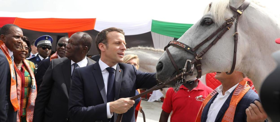 El presidente de Francia, Emmanuelle Macron, acaricia al caballo que le regalaron en su viaje a África
