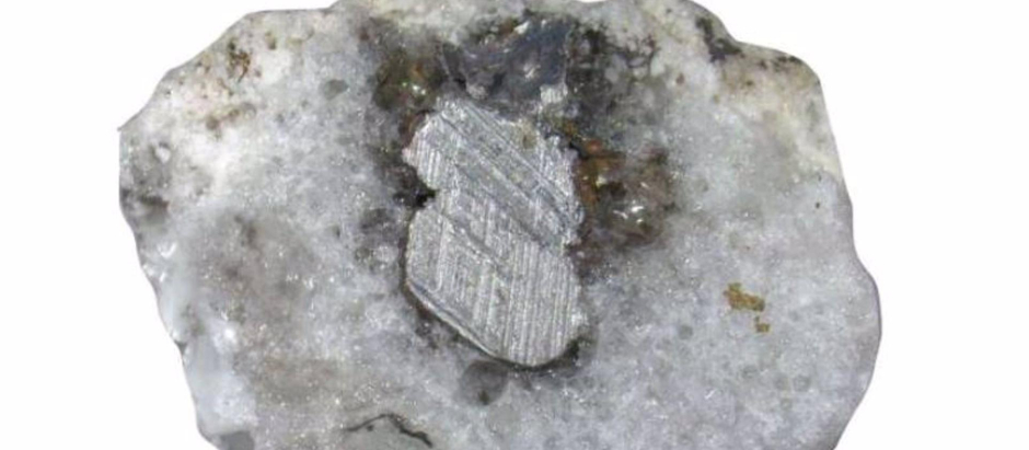 Sección transversal de una muestra de fulgurita que muestra arena fundida y metal conductor fundido de un tendido eléctrico caído