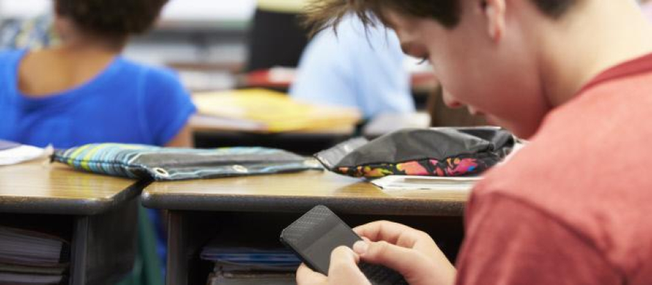 Un estudiante usa el móvil durante una clase