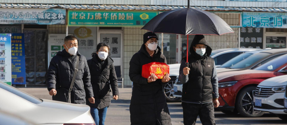 Varias personas salen de un crematorio en Pekín con una urna cineraria el pasado 4 de enero
