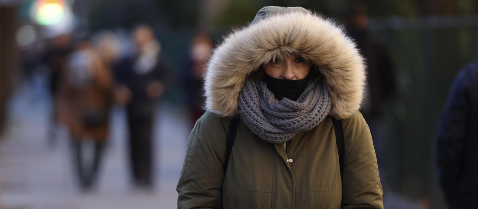 Una mujer pasea por Madrid cuando la capital se encuentra en aviso amarillo por temperaturas mínimas