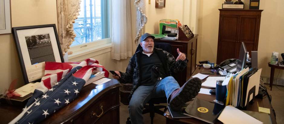 Richard Barnett, un partidario del presidente estadounidense Donald Trump se sienta dentro de la oficina de la presidenta de la Cámara de Representantes de Estados Unidos Nancy Pelosi mientras protesta dentro del Capitolio de Estados Unidos en Washington, DC.