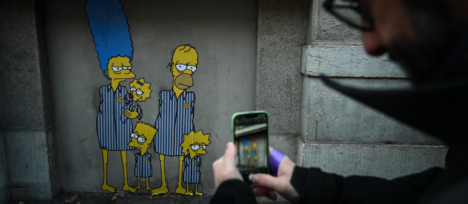 Un hombre hace una fotografía a uno de los murales de Los Simpson