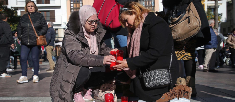 Dos mujeres encienden velas en honor al sacristán asesinado en Algeciras