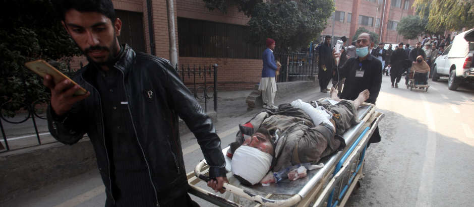Un hombre traslada en camilla a un herido en el atentado en una mezquita de Pakistán