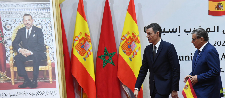 Pedro Sánchez, junto al primer ministro marroquí Aziz Akhannouch, ante un cuadro de Mohamed VI