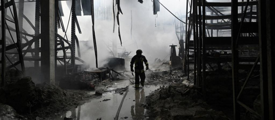 Un bombero ucraniano camina entre los restos de un centro comercial en Jersón, destruido por las bombas rusas.