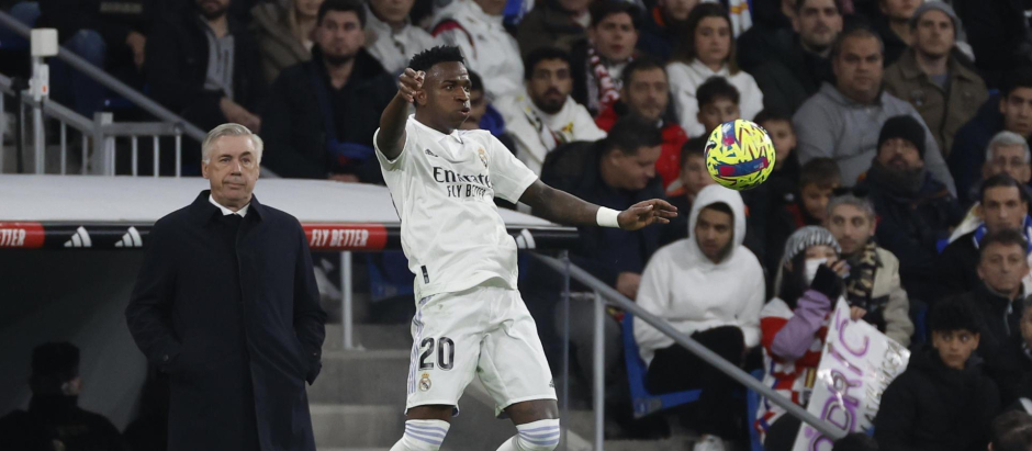 Vinicius controla un balón ante la atenta mirada de Carlo Ancelotti